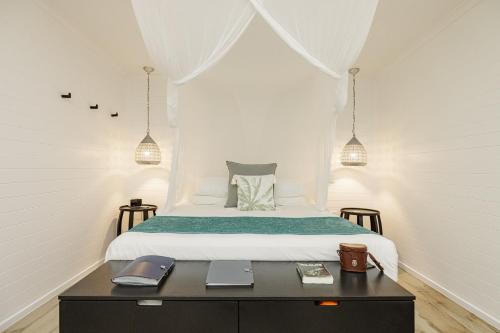 a bedroom with a bed and a table with notebooks at mist at Cape Tribulation in Cape Tribulation