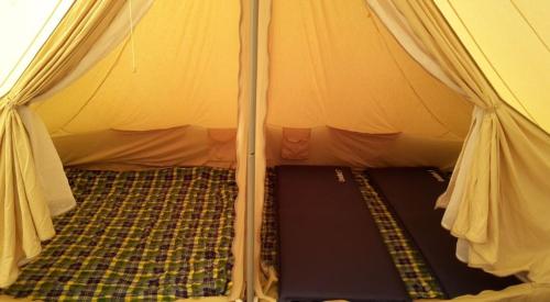 een binnenkant van een tent met een bed erin bij Ameland Tentenverhuur in Nes
