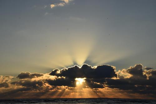 een zon verborgen achter een wolk boven de oceaan bij TY BIHAN in La Bernerie-en-Retz