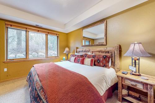 a bedroom with a large bed and a mirror at Evergreen Retreat, Unit 101 in Avon