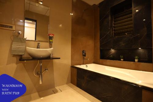 a bathroom with a sink and a bath tub at Royal Retreat - 7BHK Luxury Villa with Turf in Lonavala