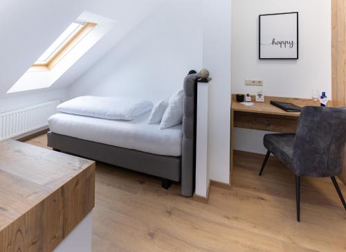 a bedroom with a bed and a desk and a chair at Self-Check-in Hotel VinoQ Zistersdorf in Zistersdorf