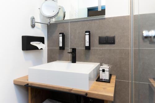 a bathroom with a white sink and a mirror at Self-Check-in Hotel VinoQ Zistersdorf in Zistersdorf