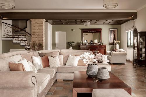 a living room with a couch and a table at Amalthia Villa in Mouzákion