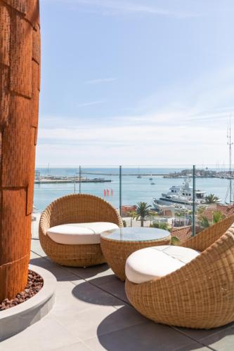 a patio with chairs and a table and a view of the ocean at Maison Marineta in Denia