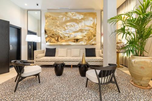 a living room with a couch and chairs and a painting at Maison Marineta in Denia