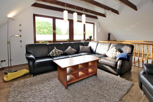 - un salon avec un canapé en cuir et une table basse dans l'établissement Badestra_e 80_ Whg_ 8_ Goting Hus, à Wyk auf Föhr