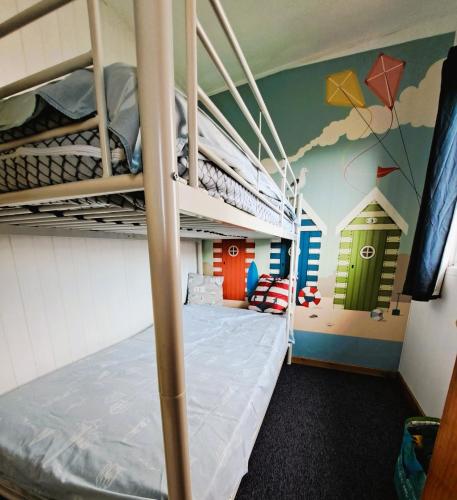 a bedroom with bunk beds and a wall with kites at Beside the Seaside Chalet in Mablethorpe