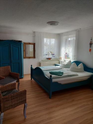 a bedroom with a large bed and a chair at Pension zum Meer in Breege