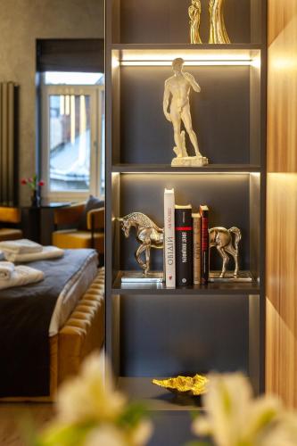 a book shelf with books and figurines on it at ARISTO Jacuzzi Hotel in Lviv