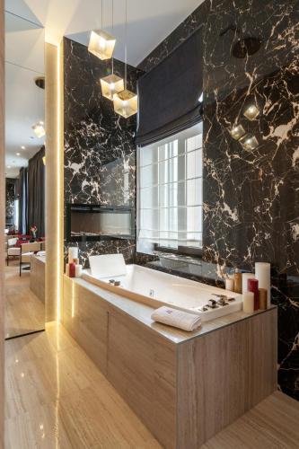 a bathroom with a bath tub in a room at ARISTO Jacuzzi Hotel in Lviv