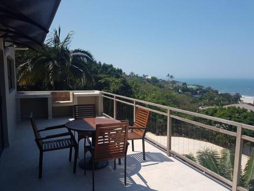 a patio with a table and chairs on a balcony at 2 bed 2 bath apartment with stunning sea views. in Ballito