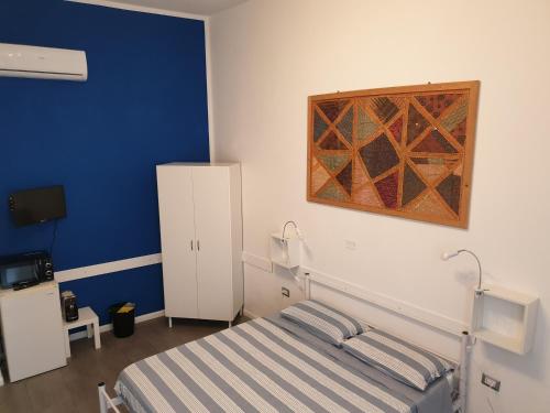 - une chambre avec un lit et une peinture murale dans l'établissement Da Laura, à Cagliari