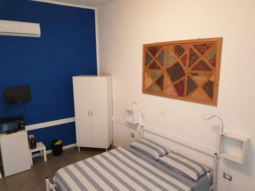 a bedroom with a bed and a painting on the wall at Da Laura in Cagliari