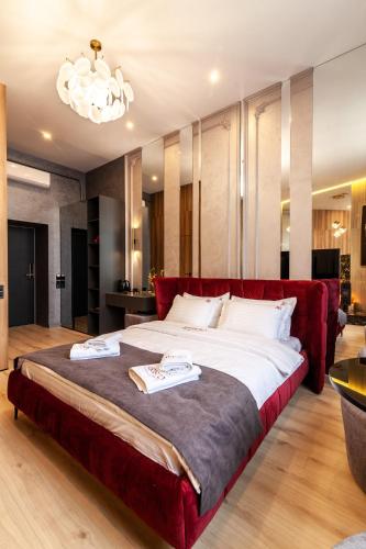 a bedroom with a large bed with a red couch at ARISTO Jacuzzi Hotel in Lviv