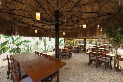 restauracja ze stołami i krzesłami oraz dużym parasolem w obiekcie Nomade Caravan Camping w mieście Fethiye