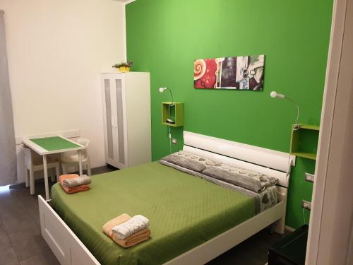 a green bedroom with a bed and a table at Da Laura in Cagliari
