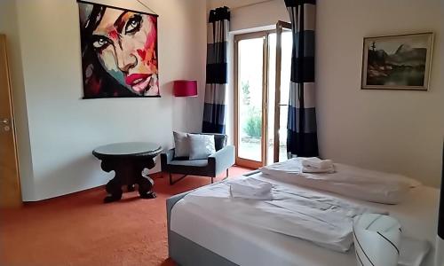 um quarto com duas camas e uma cadeira e um quadro em ciao-aschau Haus Beate em Frasdorf