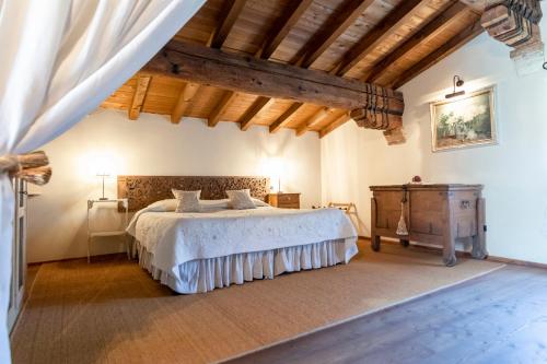 a bedroom with a large bed and a wooden ceiling at Musella Winery & Relais in San Martino Buon Albergo