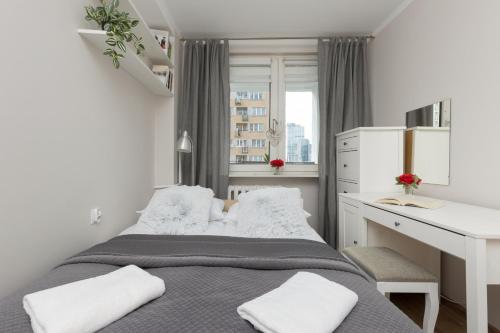een kleine slaapkamer met een bed en een bureau bij Pet-Friendly Apartment Pańska with AC by Renters in Warschau