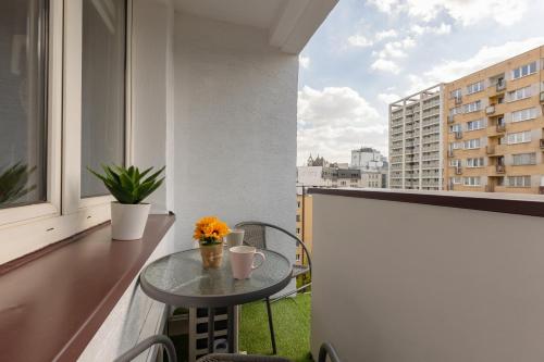 een kleine tafel op een balkon met een raam bij Pet-Friendly Apartment Pańska with AC by Renters in Warschau