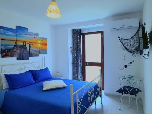 Dormitorio azul con cama y ventana en Caldi Abbracci, en Meta