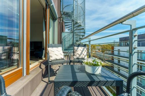 ミエンジズドロイェにあるW Rent like home - Tulipan Penthouse IIIのバルコニー(椅子2脚、テーブル付)