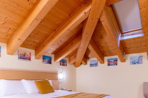 Camera con letto e soffitto in legno. di Hotel Autoespresso Venice a Marghera