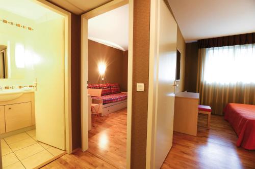 a room with a bedroom with a bed and a bathroom at La Villa Du Lac- 3 rooms for 6 people in Divonne-les-Bains