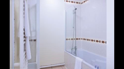 a white bathroom with a tub and a shower at La Villa Du Lac- 3 rooms for 6 people in Divonne-les-Bains