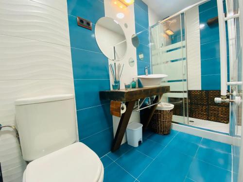 La salle de bains bleue est pourvue de toilettes et d'un lavabo. dans l'établissement Raices, à Robledondo