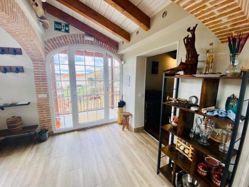 a living room with a large window and a wooden floor at Raices in Robledondo