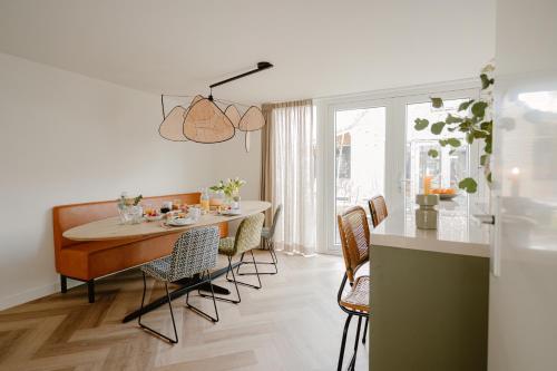 a kitchen and dining room with a table and chairs at Dromen in de duinen by Droomvilla in Sint Maarten