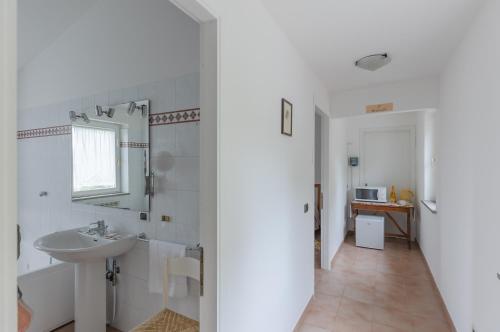 Baño blanco con lavabo y espejo en Oak House Apartments with parking en Perugia