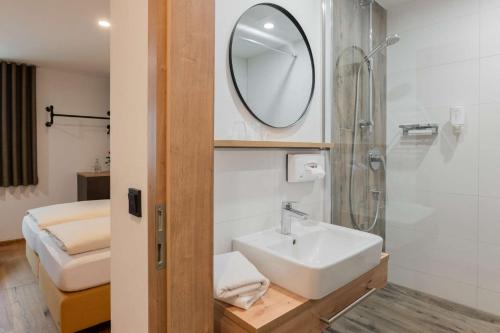 La salle de bains est pourvue d'un lavabo, d'une douche et d'un miroir. dans l'établissement Gasthof Krone, à Kinding