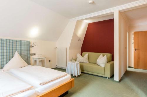 a bedroom with a bed and a couch at Gasthof Krone in Kinding