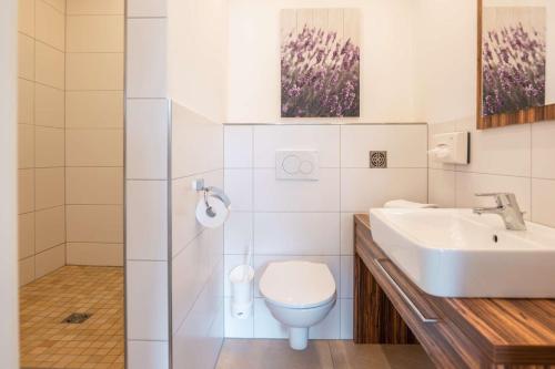 a white bathroom with a sink and a toilet at Gasthof Krone in Kinding