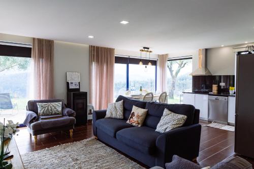 a living room with a blue couch and a kitchen at Boavista Country Houses no 87 in Cabeceiras de Basto