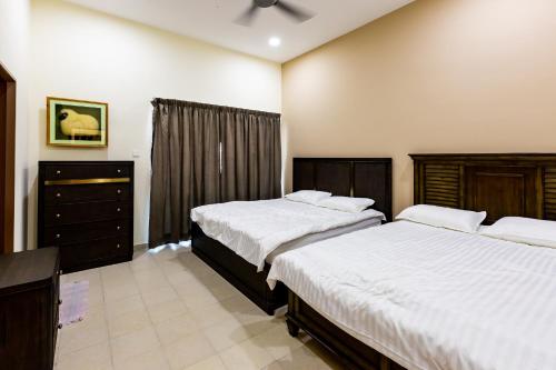 a bedroom with two beds and a dresser at HyperTribe -Pangkor Holiday Home in Kampong Sungai Udang