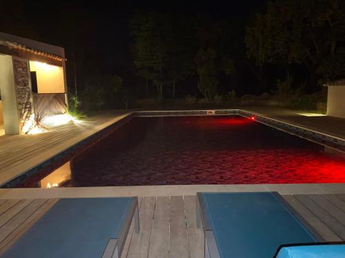 a swimming pool at night with red lights in it at Magnifique villa avec piscine au coeur des vignes in Cogolin