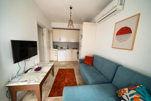 a living room with a blue couch and a table at Ilya Apart 1 in Bodrum City