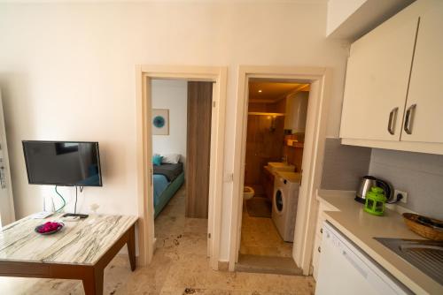 a kitchen with a table and a television in a room at Ilya Apart 1 in Bodrum City