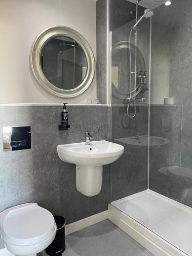 La salle de bains est pourvue d'un lavabo, de toilettes et d'une douche. dans l'établissement Hunley Golf Club, à Saltburn-by-the-Sea