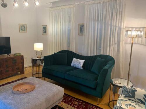 a living room with a green couch and a tv at Casa Veronica in Sibiu