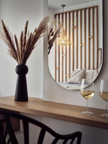 a table with a mirror and two glasses of wine at Cassiopeia Rooms & Suites in Laganas