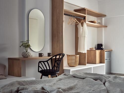 拉加納斯的住宿－Cassiopeia Rooms & Suites，一间卧室配有一张床、镜子和椅子