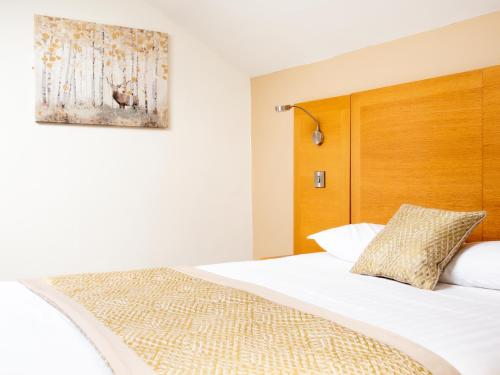 a bedroom with a bed with a wooden headboard at The Old Ginn House Inn in Great Clifton