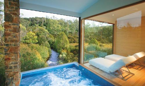 a jacuzzi tub in a room with a large window at Peppers Cradle Mountain Lodge in Cradle Mountain