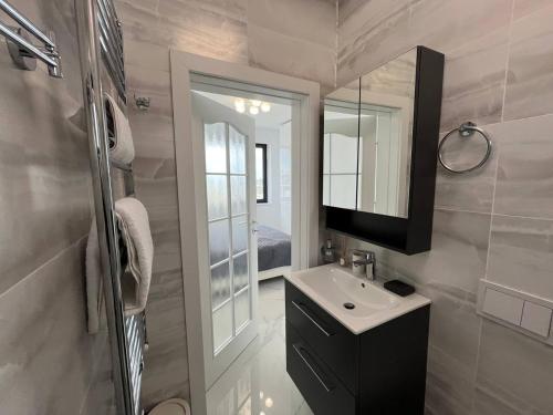 a bathroom with a sink and a mirror at Luxury apartment with sea view in Mamaia Sat/Năvodari