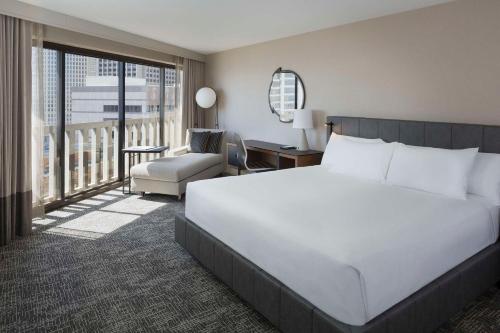 um quarto com uma grande cama branca e uma cadeira em Hyatt Regency San Francisco em São Francisco